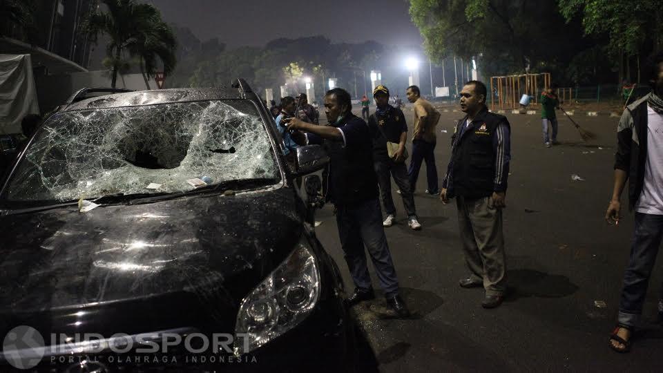 Sebuah mobil tampak rusak parah pasca kerusuhan oknum The Jakmania di luar area Stadion GBK, Jumat (24/06/16).